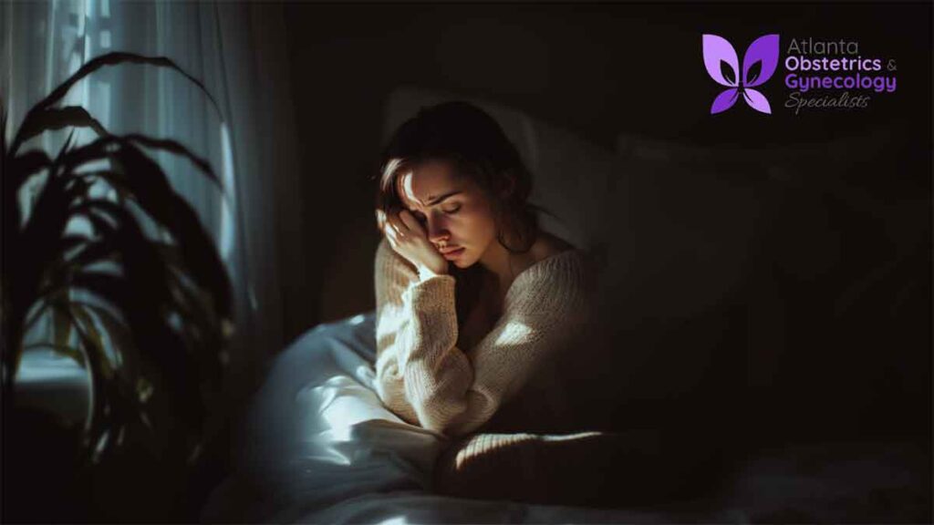 Woman in bed looking anxious and deep in thought.