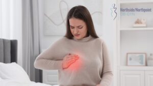 Woman clutching her chest with a painful expression