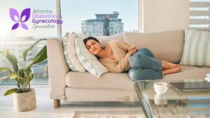 Woman lying on a couch holding her lower stomach in pain