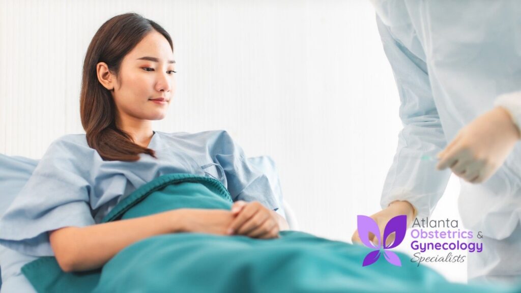 A woman sitting on her bed, recovering after an OB/GYN procedure